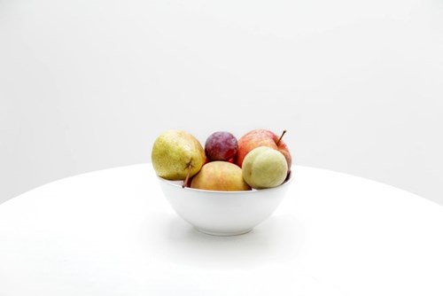 Frukter i en skål mot vit bakgrund